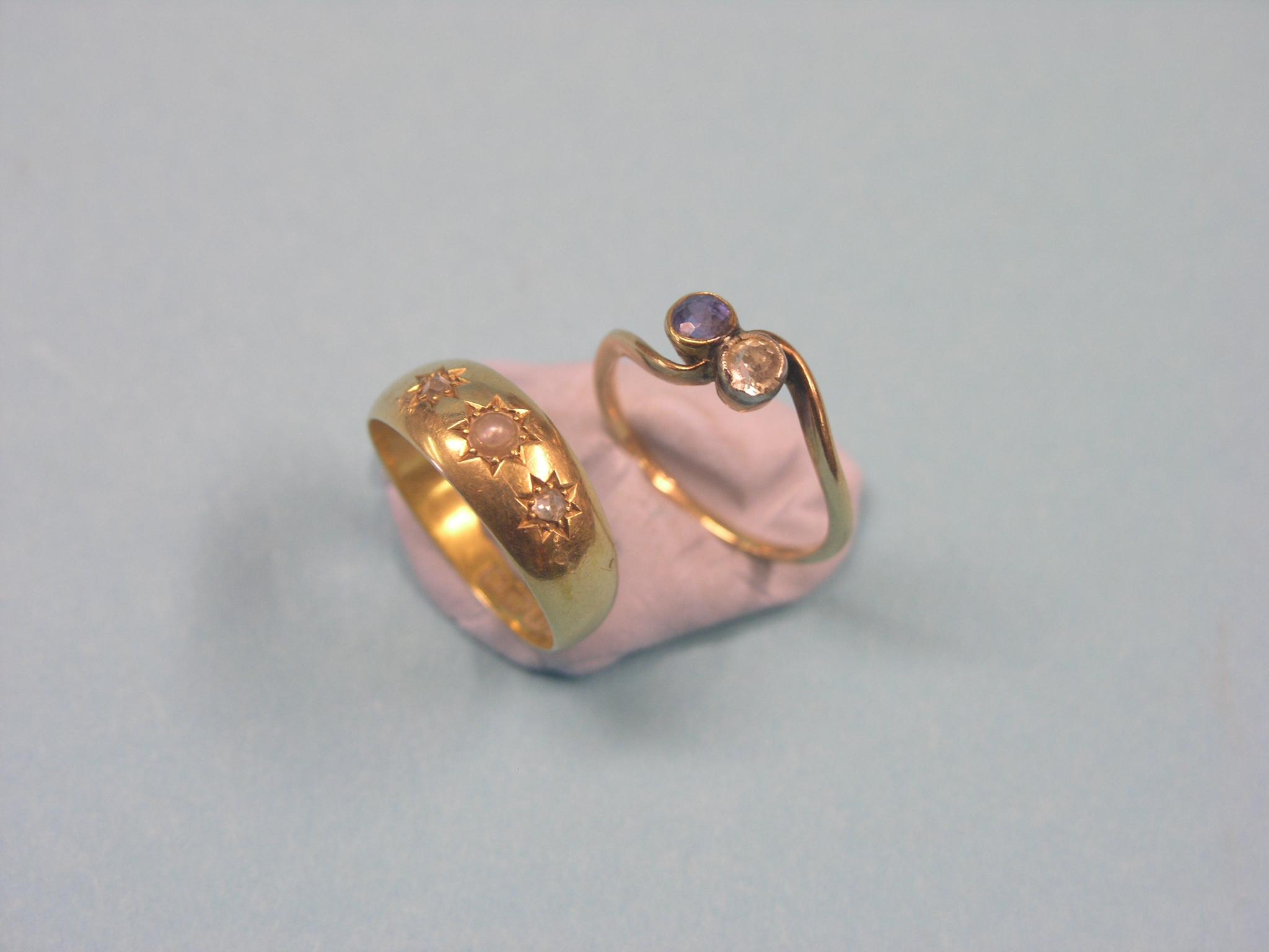 An 18ct. gold ring, gypsy-set with two diamond chips and central pearl, and a gold cross-over