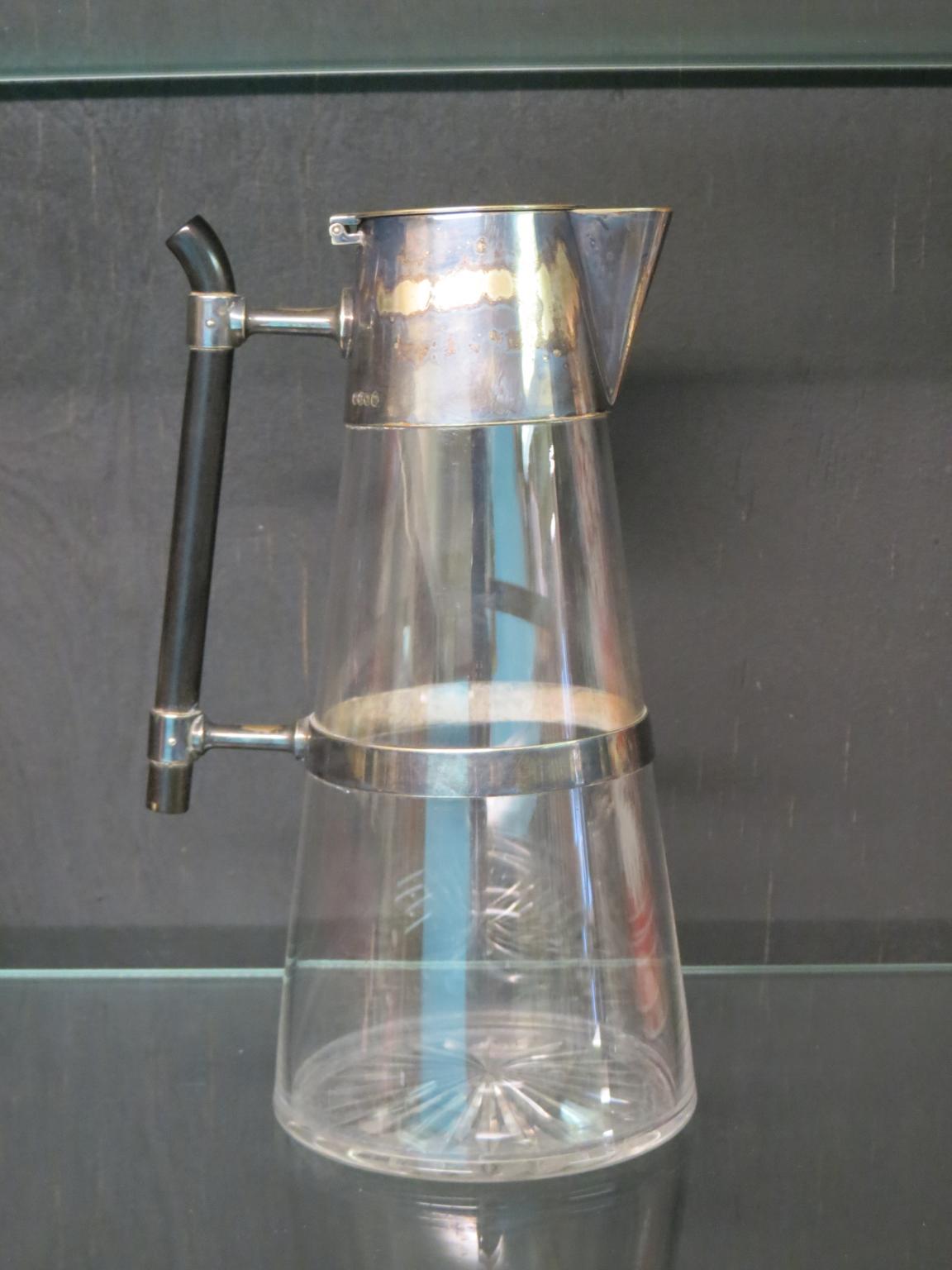 A Victorian claret jug designed by Christopher Dresser, tapering glass with silver plated mounts,