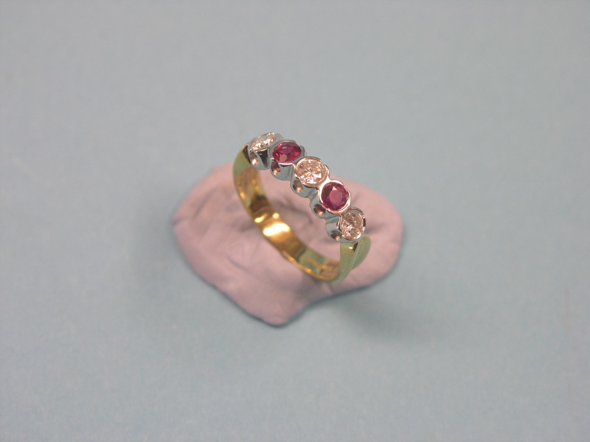 An 18ct. gold, diamond and ruby half-hoop ring, three diamonds, two rubies, size N