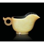 A small jade jug, China, 1900s - Yellow jade and russet. 6x10.5cm - Startprice : - [...]