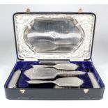 A George V silver seven piece silver backed dressing table set with engine turned ornament and