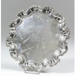 An 18th Century silver circular waiter with shaped and moulded rim, engraved with crest to centre,