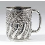 A late Victorian silver christening mug, the cylindrical body partly reeded, embossed and chased