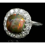 A modern 18ct white gold and platinum mounted opal and diamond set ring, the cabochon cut opal of