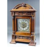 A late 19th Century German walnut cased mantel clock, the brass dial with 5.5ins diameter silvered
