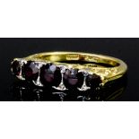 A modern 18ct gold and platinum mounted five stone ruby and diamond ring, the circular cut ruby