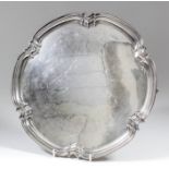 An Elizabeth II silver circular salver with shaped and moulded rim, on three panel feet, 12.25ins