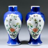 A pair of Chinese Famille Verte baluster-shaped vases painted with flowering branches and rock