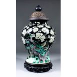 A Chinese porcelain Famille Noire baluster-shaped vase enamelled with flowering prunus, rockwork and