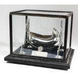 A George V silver and silver gilt model of a cradle of oval form and with gadroon mounts, on twin