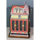 A 1950s American Mills F.O.K. slot machine (to take five Cents), contained in oak case with ornate