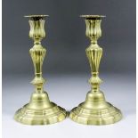 A pair of 18th Century French seamed brass candlesticks with knopped stems and shaped bases, 9.25ins
