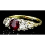 A modern 18ct gold mounted ruby and diamond ring, the circular cut ruby of .80ct, shouldered by