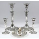 A pair of Edward VII silver oval pillar candlesticks of Neo-Classical fluted form, with urn