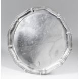 A George V silver circular salver of shaped and moulded outline, on three shaped feet, 12.5ins