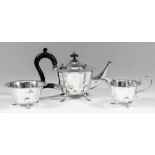 A George V silver circular three piece tea service with shaped rim, scroll handles and on scroll