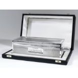 An Elizabeth II silver rectangular cigarette box with scroll cast mounts and engine turned panels to
