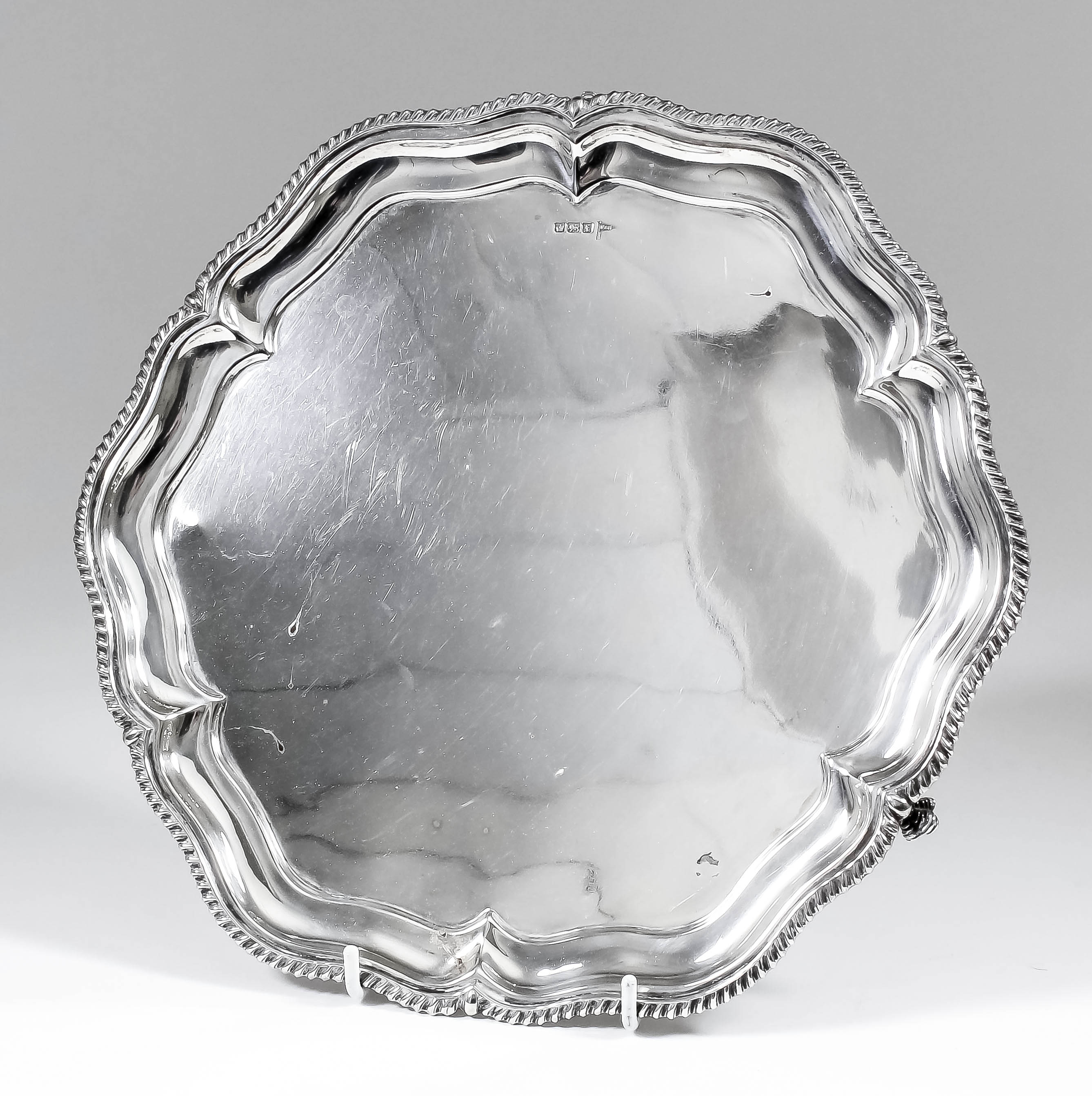 A George V silver circular salver of "Georgian" design, the shaped and moulded rim with gadroon