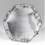 A George V silver circular salver of "Georgian" design, the shaped and moulded rim with gadroon