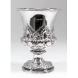 A George IV silver goblet with moulded rim, chased and embossed with floral and leaf ornament to