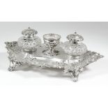 An early Victorian silver oval inkstand of shaped and moulded outline, with scroll mounts and
