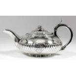 A George IV silver circular teapot of bulbous squat form with gadroon mounts, floral pattern