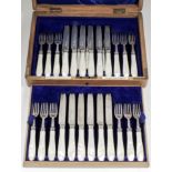 A set of twelve George V silver and mother-of-pearl handled fruit knives and forks, by The Goldsmith