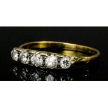 A late Victorian 18ct gold mounted five stone diamond ring, the central old cut stone of