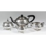 An Edward VII silver circular four piece tea service of bulbous form and with hammered finish and