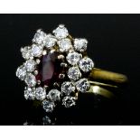 A modern 18ct gold mounted ruby and diamond oval cluster ring, set with a central ruby approximately