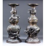 A pair of Japanese bronze vases of double bulbous form, cast with three-clawed dragons amongst