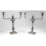 A pair of Indian silvery metal three light candelabra, the central columns with bulbous reeded knops