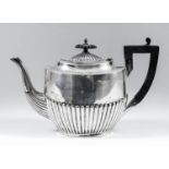 A George V silver oval teapot with part reeded body, ebonised finial and angular loop handle, 7.