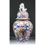 A Japanese porcelain "Imari" pattern baluster shaped vase with domed cover, reeded moulded body,