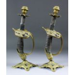 A pair of late 19th Century Continental brass mounted sword hilt candle sticks, 12.25ins high