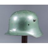 A First World War German steel helmet, interior stamped with "ET64", finished in later green paint