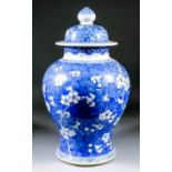 A Chinese blue and white porcelain baluster-shaped vase and cover painted with prunus blossom, on