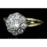 A 14ct gold and platinum mounted all diamond set flowerhead pattern ring the central old cut diamond