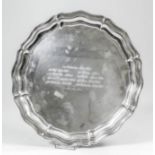 An Indian silvery metal circular salver with shaped and moulded rim and four ball feet, 12ins