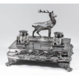A late Victorian plated rectangular ink stand surmounted by figure of a stag, the front cast with