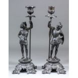 A pair of 19th Century bronzed metal candlesticks modelled as 16th Century courtiers holding the