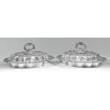 A pair of plated oval entree dishes of shaped outline with cast floral and C-scroll mounts, the