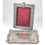 A late Victorian silver rectangular photograph frame embossed with C-scroll and leaf ornament (to