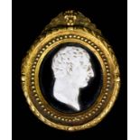 A 19th Century glass cameo, possibly by Tassie, of a classical male head in embossed gilt metal oval