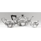 An Edward VII silver three piece tea service of rectangular lobed form, embossed with C-scroll and