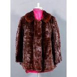 A lady's short mink jacket by The Weald Furriers, lined, size 10/12, 24ins long, a fur muff, two