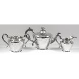 A Victorian silver three piece tea service of cylindrical tapered form, engraved with scroll, leaf