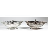 A pair of George I "Irish" cast silver double-lipped sauce boats with shaped and moulded rims and