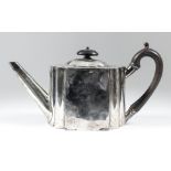A George III plain silver oval tea pot with flattened sides and shaped ends, ebonised C-scroll
