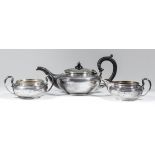 A George V silver circular three piece tea service of bulbous squat form with moulded rims and